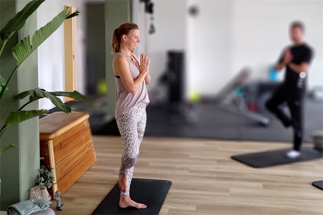 Yogapose op mat door yog-instructrice